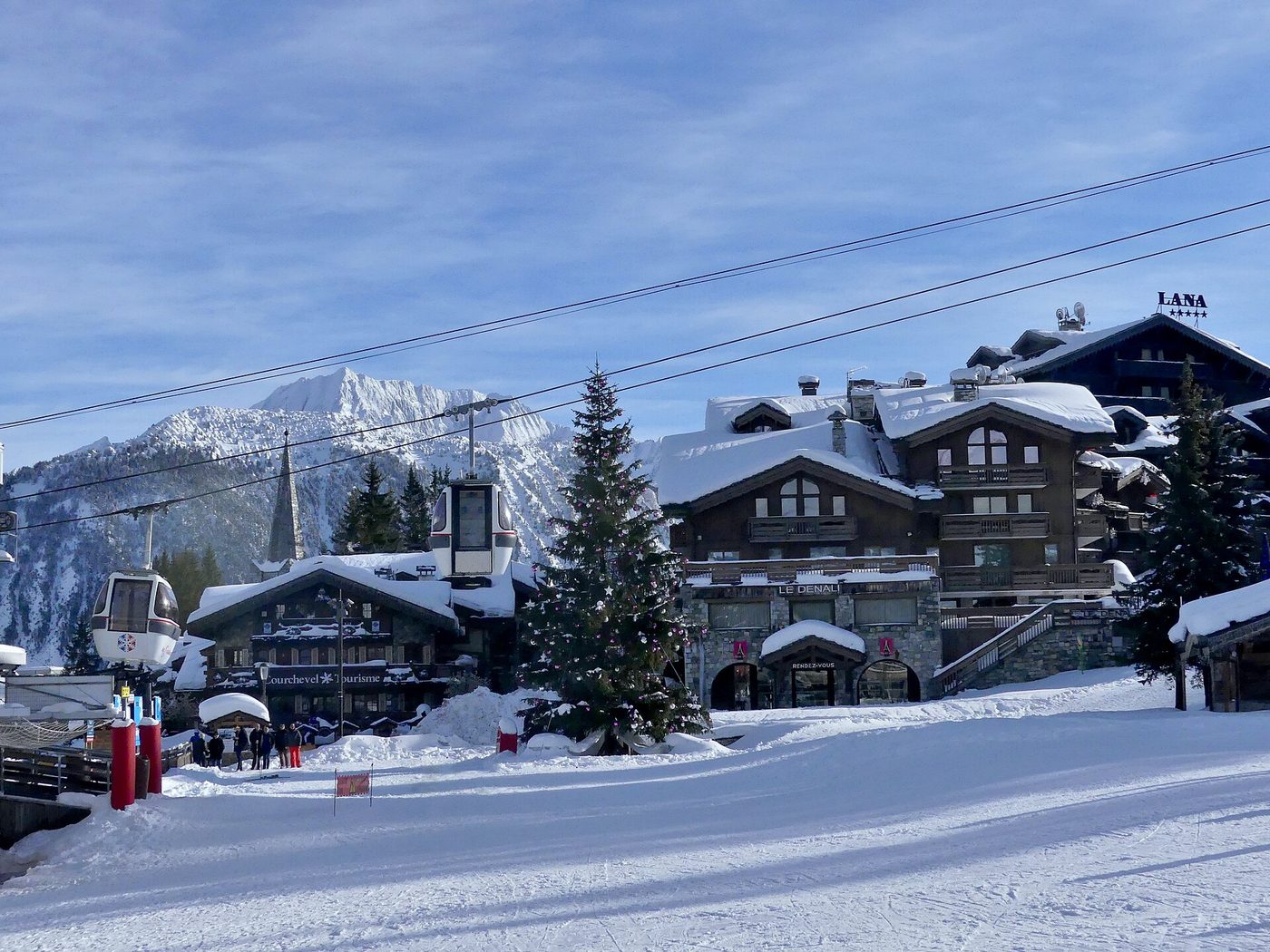 The Courchevel 1850 village and ski resort front on a snowy winter morning with chalets and ski lifts