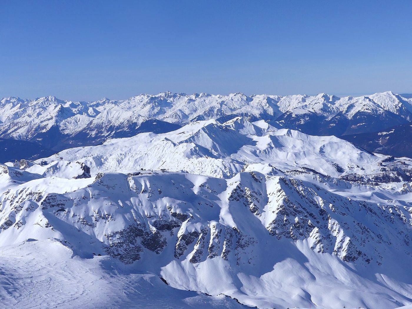 Aerial panoramic view of the La Plagne ski domain from Bellecôte showing Roche de Mio and the wide piste network