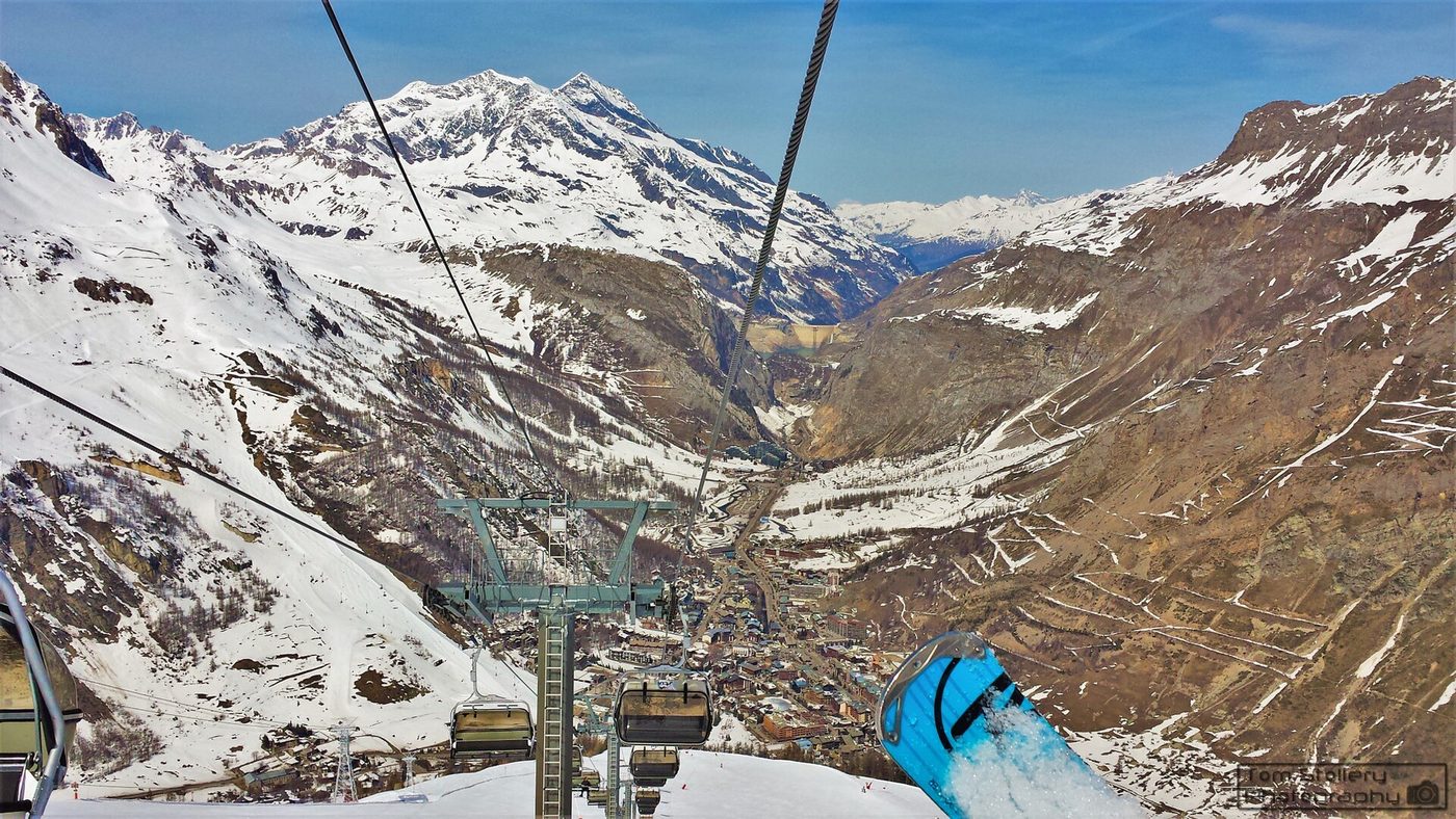 View from a chairlift high above Val d'Isère looking down into the deep Alpine valley with the resort nestled below in winter snow