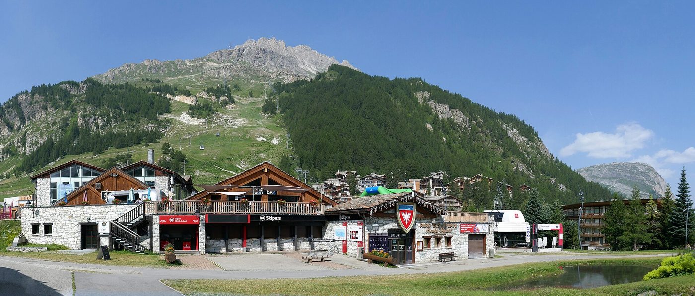 Val d'Isère village seen from across the valley with the rocky Rocher de Bellevarde summit looming behind the chalets and resort buildings