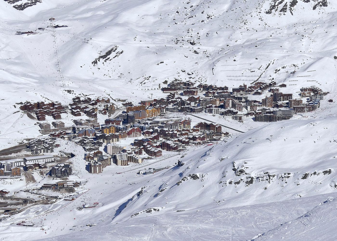 Aerial view of the Val Thorens resort village surrounded by snow-covered slopes and peaks in winter
