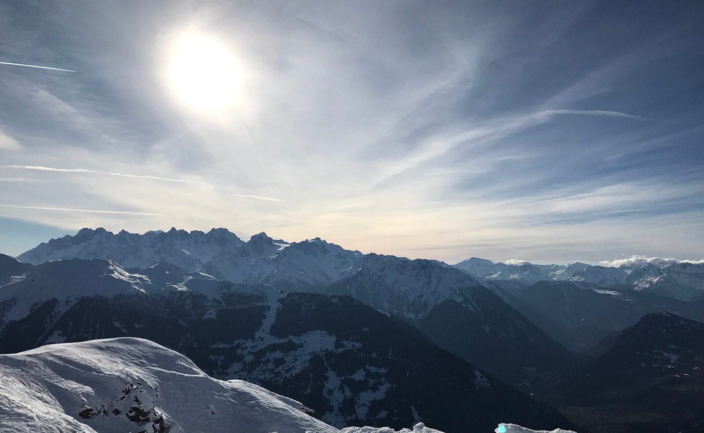Wide panoramic view of snow-covered Valais Alps peaks from above Verbier resort, clear blue sky above the summits
